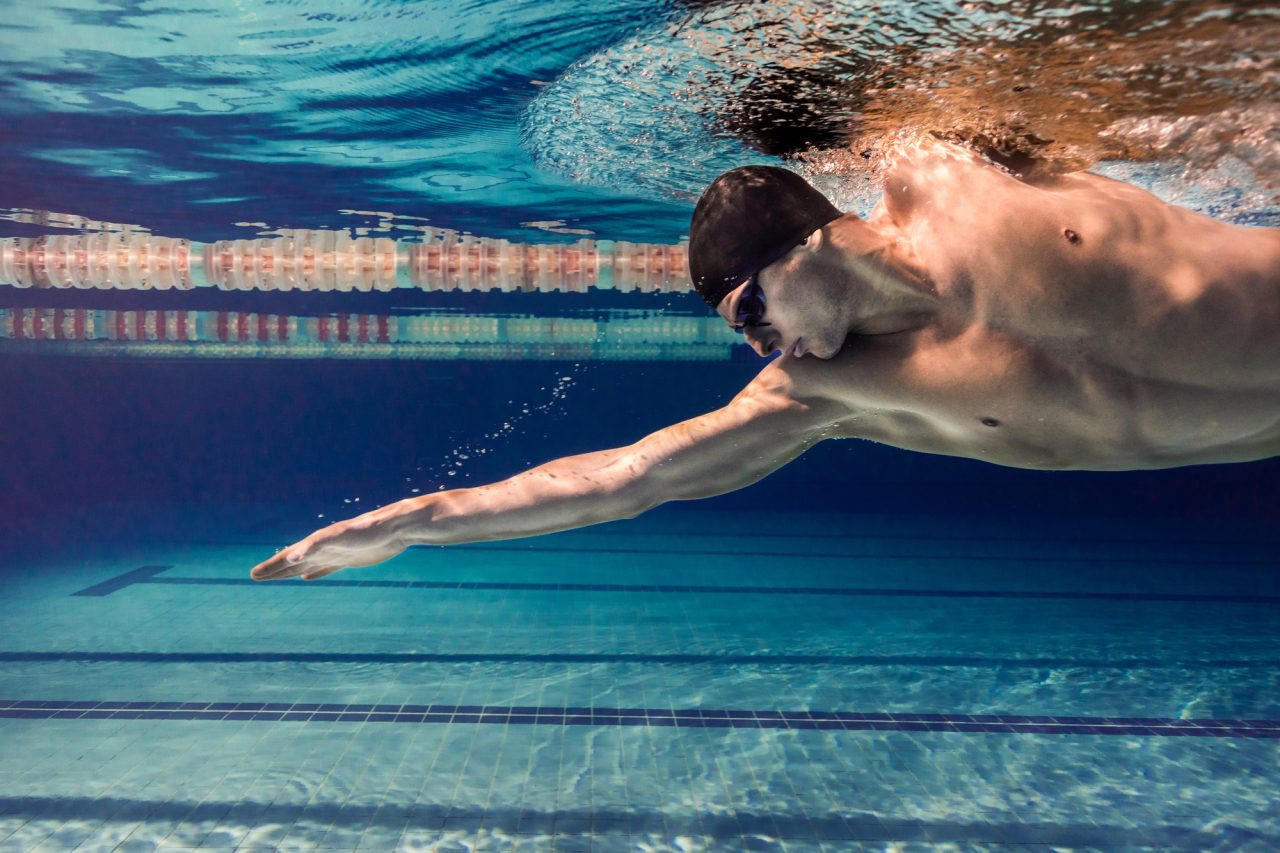 How Much Does Swim Instructor Certification Cost in New York? Swimmer demonstrating a streamlined glide, a skill assessed during swim instructor certification