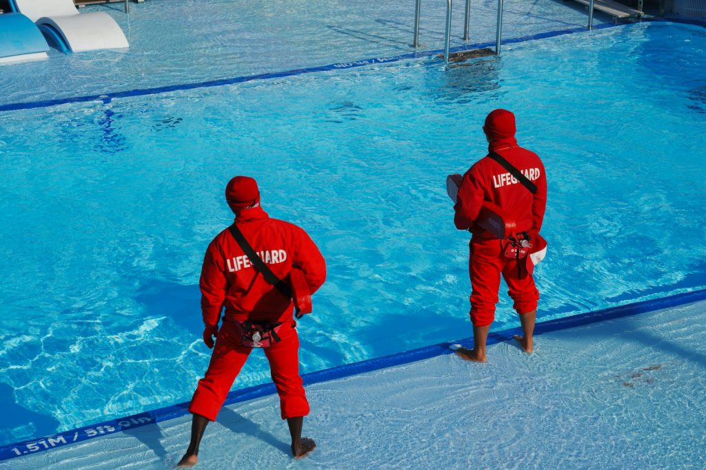 Certified lifeguards on duty at an outdoor pool, the cover you get when you hire a lifeguard for a pool party